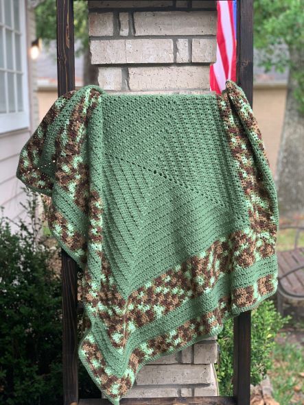 green and camo square baby blanket on blanket ladder