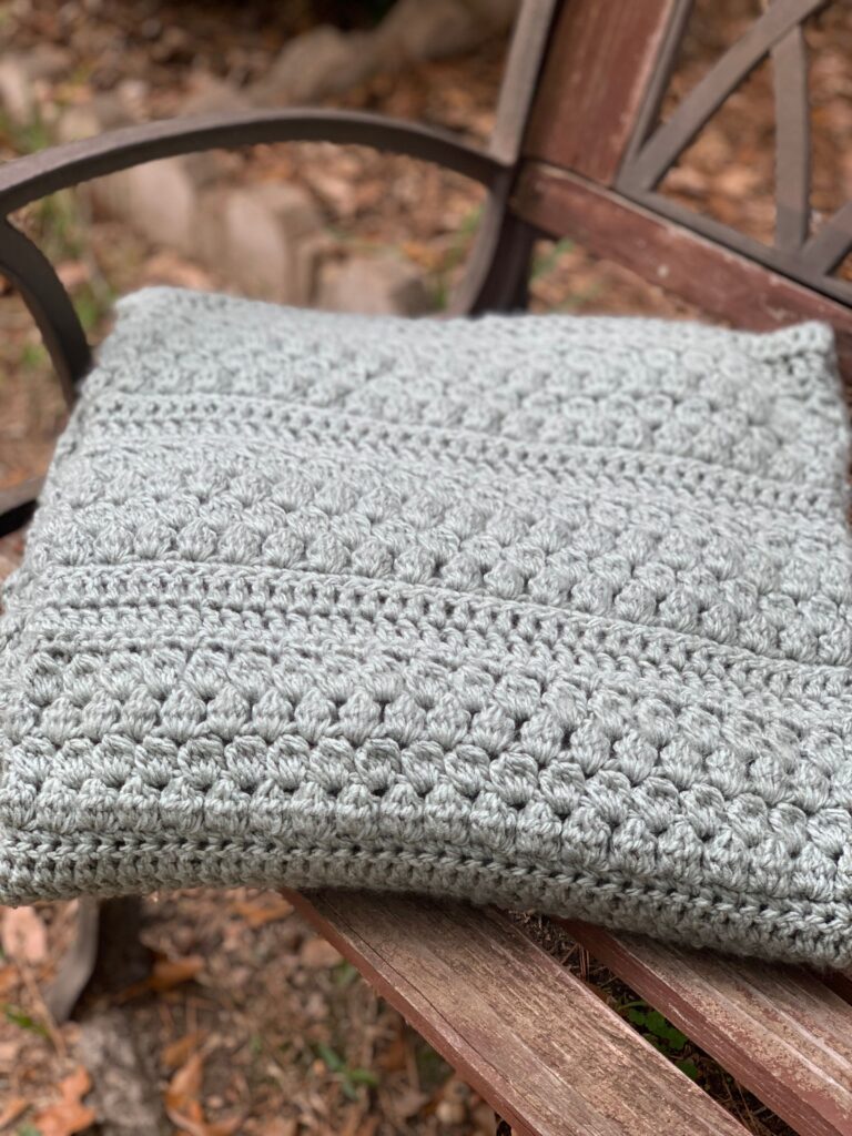 crochet blanket laying on outdoor bench