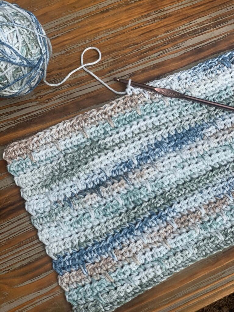 detail photo of spike single crochet placemat progress with yarn and crochet hook