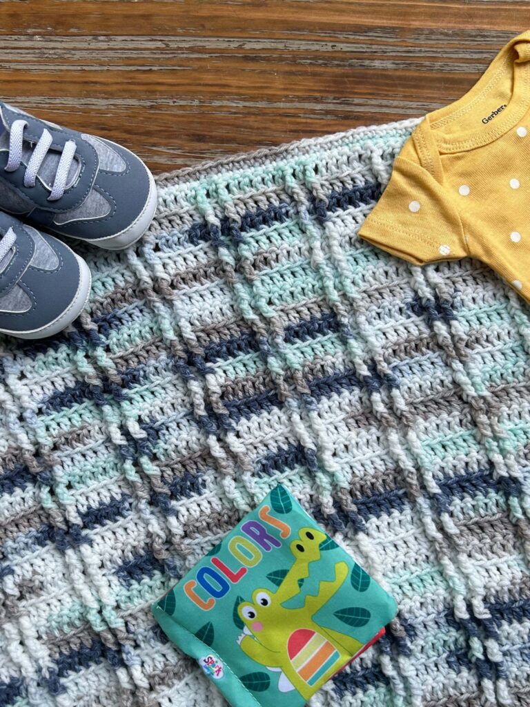 textured baby blanket, baby shoes, baby shirt, soft book about colors