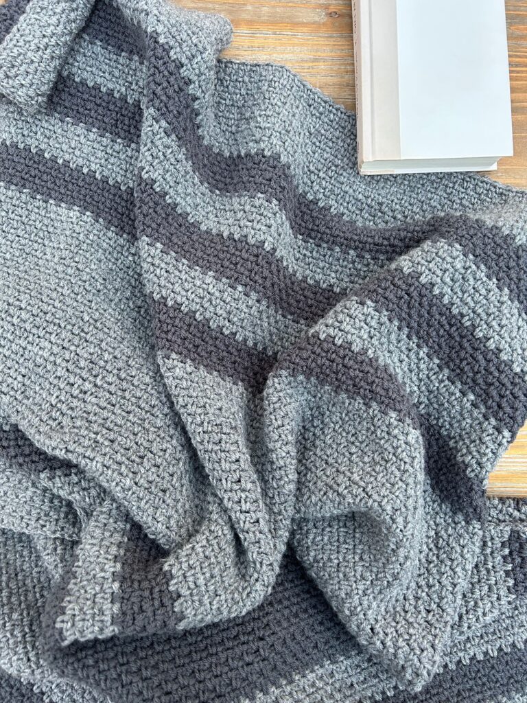 striped gray blanket with book