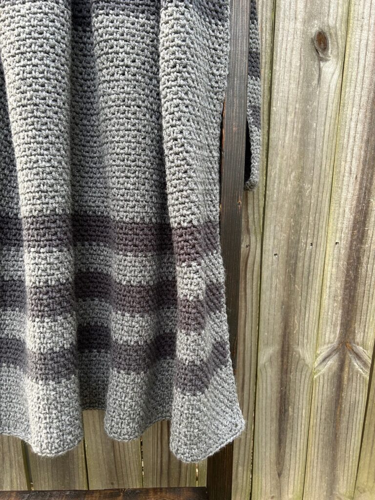 striped gray blanket on blanket ladder against fence