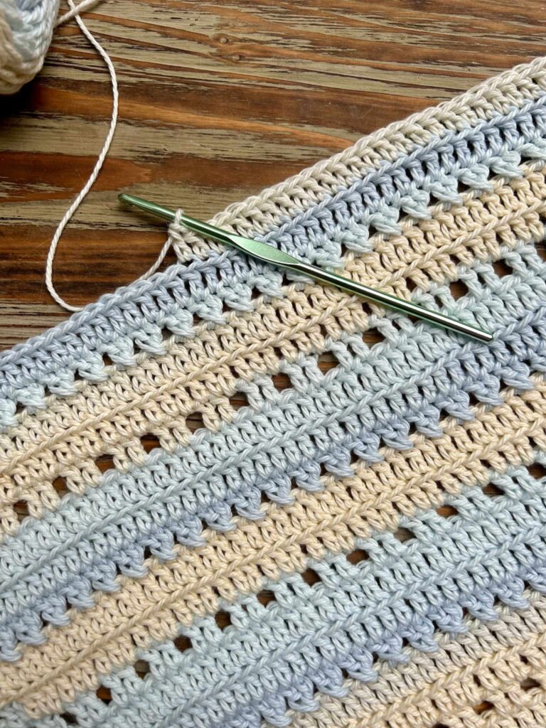 Easy crochet project with yellow and blue yarn and a green crochet hook