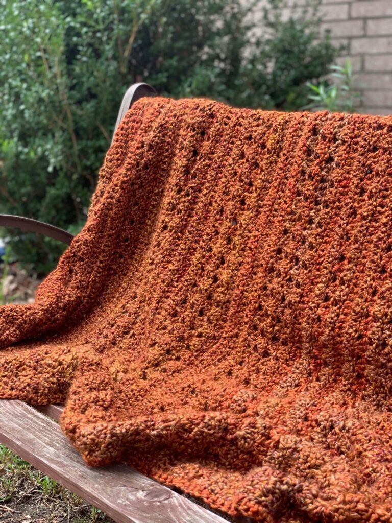 Orange throw blanket on outdoor bench
