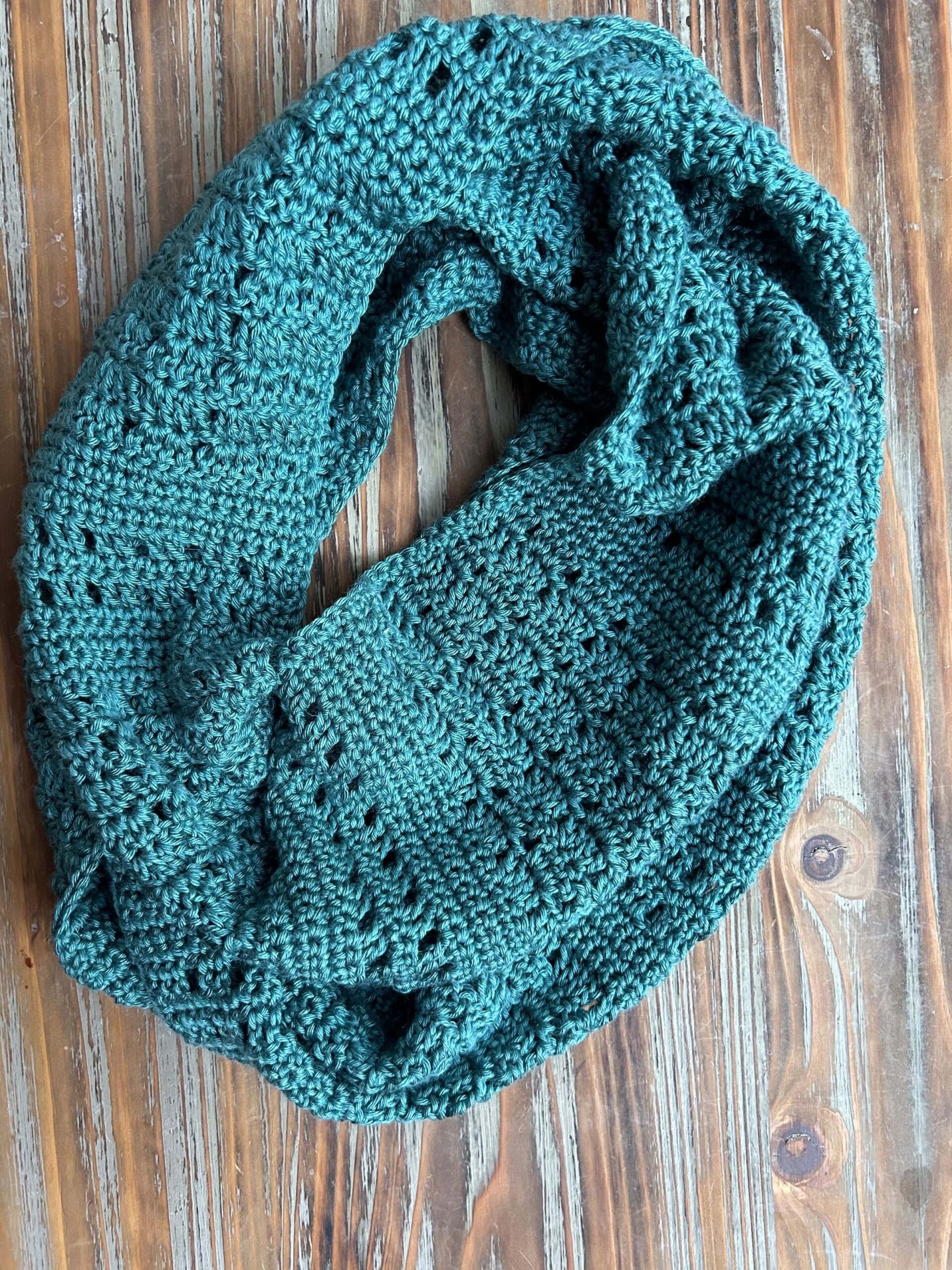 Lightweight crochet infinity scarf on wooden background