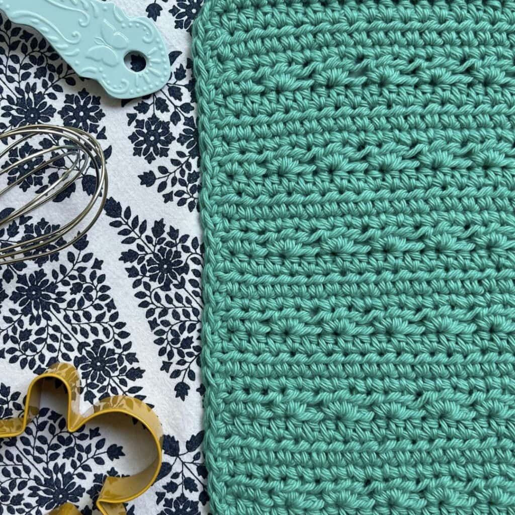 closeup of crochet dishcloth with kitchen items