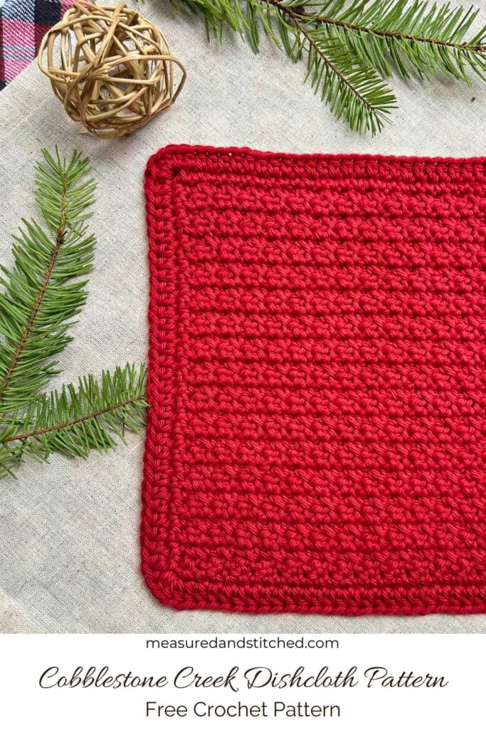 red crocheted dishcloth with winter decor in background, text reads "measuredandstitched.com, Cobblestone Creek Dishcloth Pattern, Free Crochet Pattern"