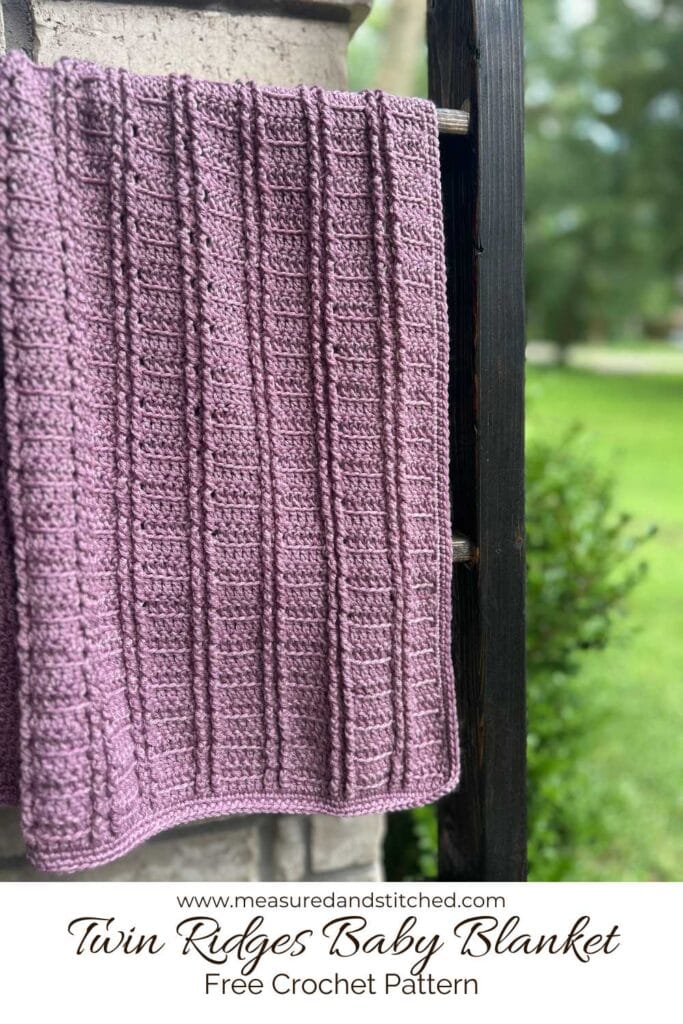 Crochet baby blanket on outdoor blanket ladder, overlay text reads "www.measuredandstitched.com, Twin Ridges Baby Blanket, Free Crochet Pattern"