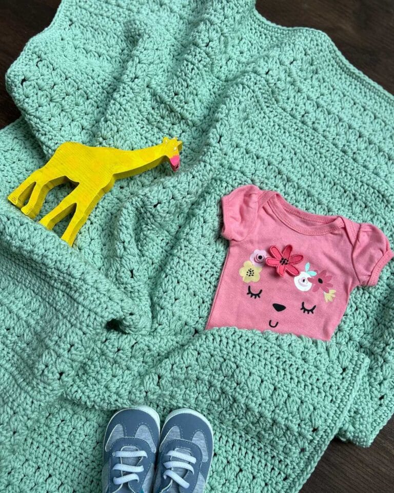 cluster stitch crochet baby blanket with baby items