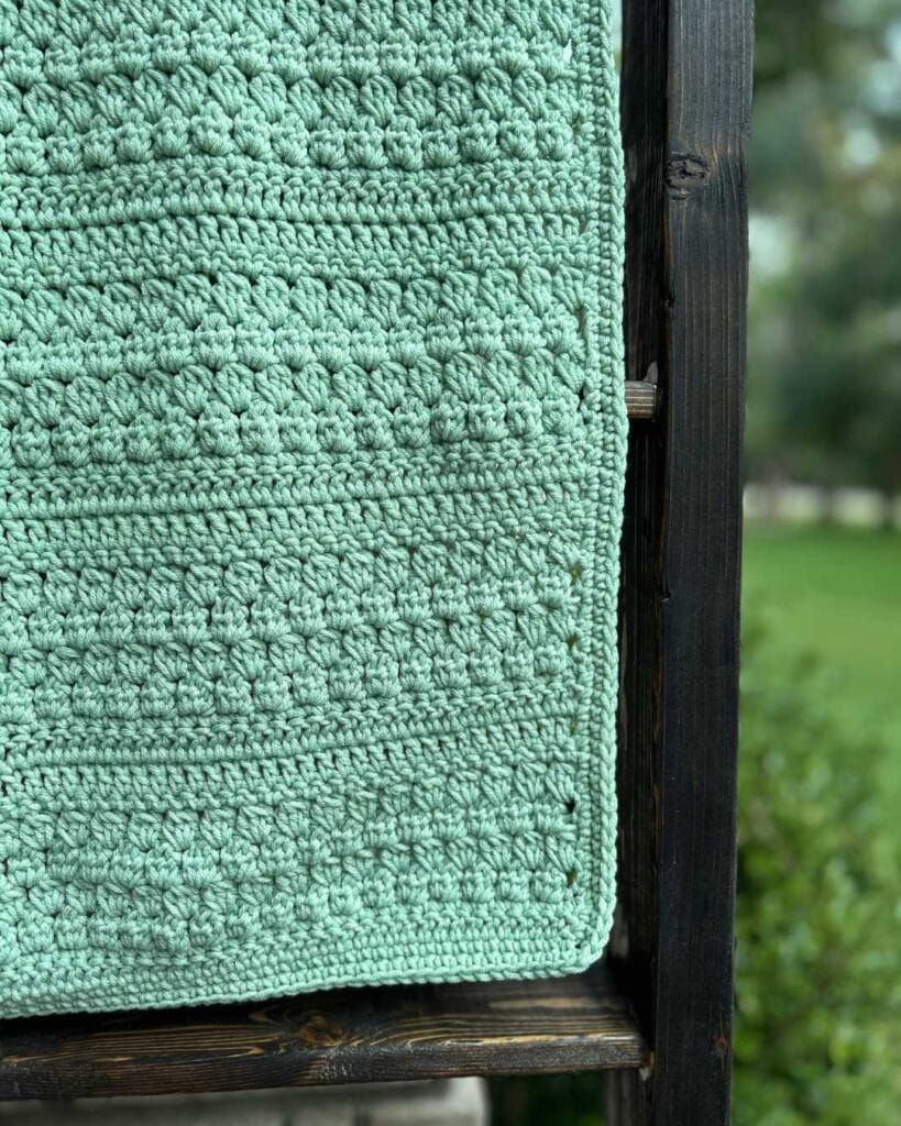 green crochet project on blanket ladder
