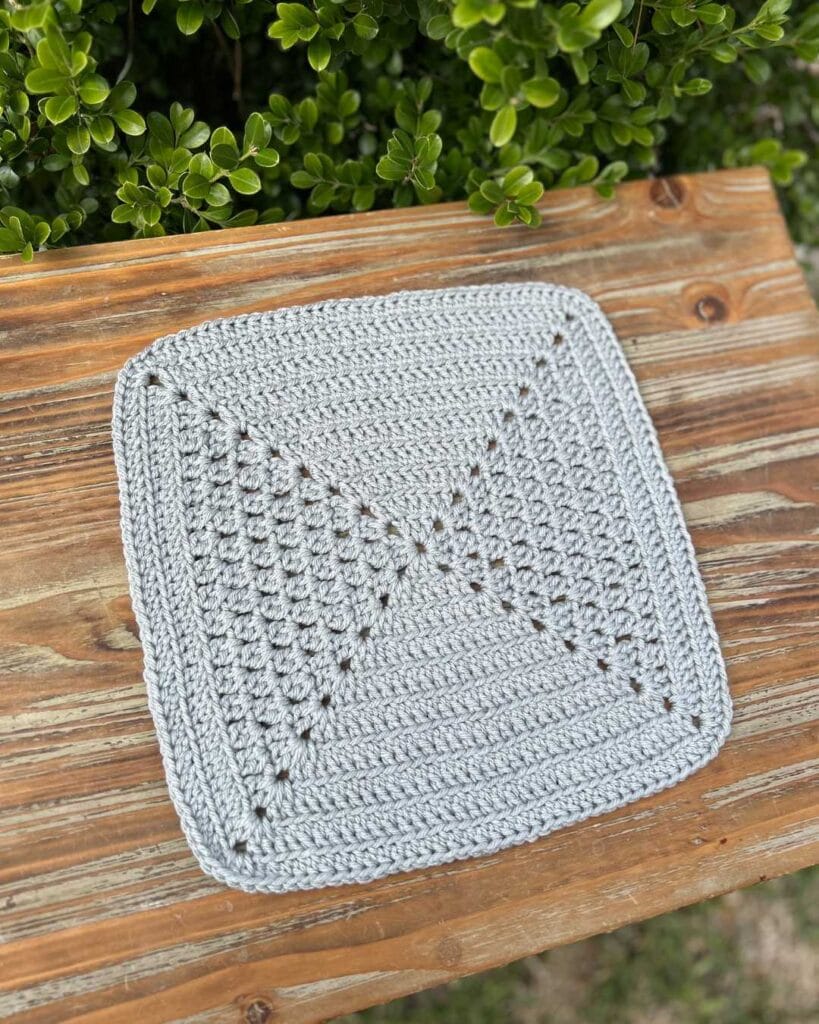 square crochet project on wooden table