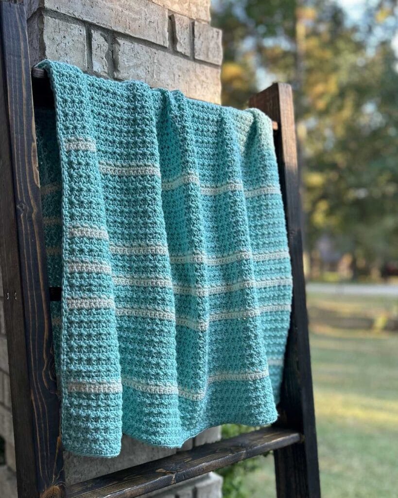 textured crochet baby blanket on blanket ladder