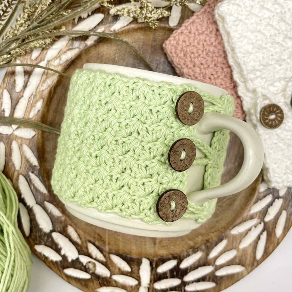 crochet mug cozy with wooden buttons on coffee mug